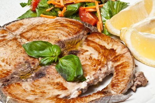 cooked swordfish served with salad and lemon