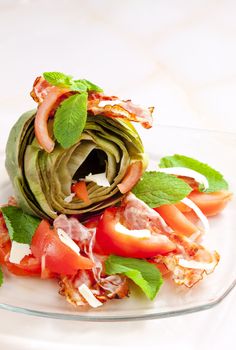 cooked artichoke with tomatoes, parmesan cheese, pancetta, and mint