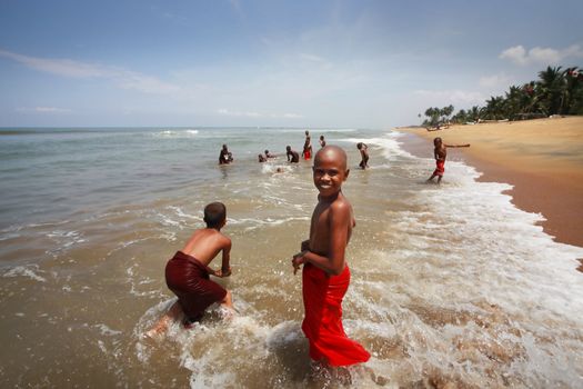 SRI LANKA, KALATURA - 08 APRIL, 2011: School of the Buddhism. Young Buddhists bathe at ocean in a break between lessons 08 april in Kalatura, Sri lanka (Ceylon)