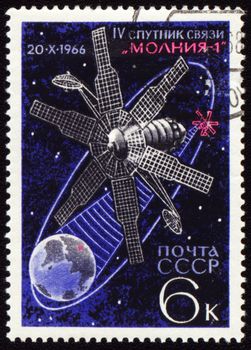 Postage stamp printed in USSR shows soviet communication satellite Molnia-1 on Earth orbit, circa 1966