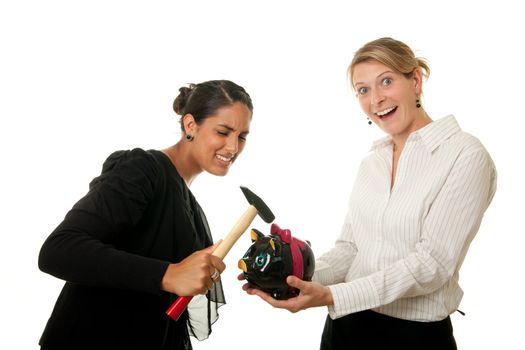 two young women breaking a piggybank with a hammer