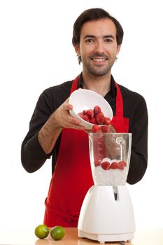 a chef pouring some strawberries into a blender