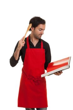 a thinking chef reading in a cookbook scratching his head with a spoon