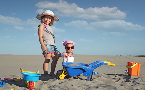 two little girl fun and play in sand