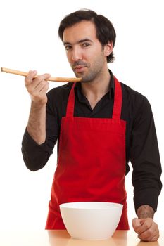 a chef tasting with a spoon trying to cool the food down