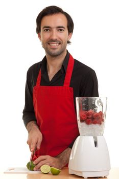 a chef with a blender in front of him cutting a lime with a kitchen knife