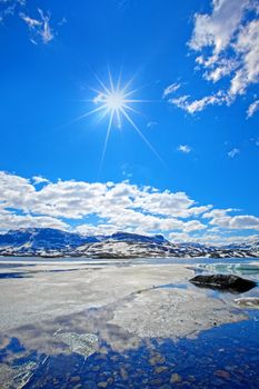 Snowcapped mountains reflecting in the water at Haukeli, Norway