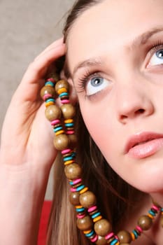 Beautiful female model with blue eyes and a string beads