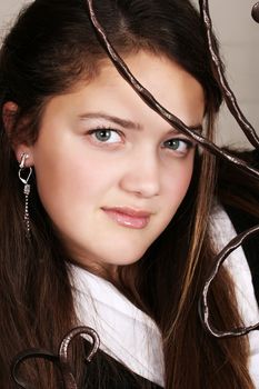 Female teenager looking through wrought iron bars