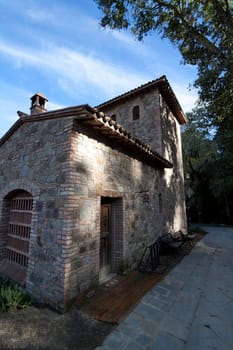 An old stone house sitting next to a forest