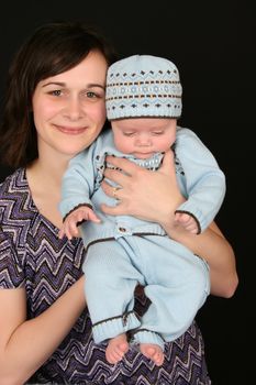 Beautiful brunette mother with her baby boy dressed in blue 