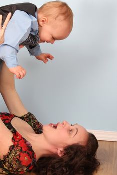 Mother and son playing indoors on a wooden floor