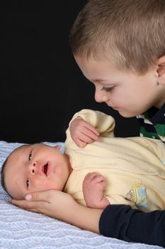 Blond boy looking at his newborn baby brother