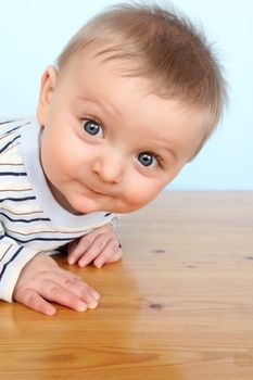 Beautiful 6 month old baby boy against blue background