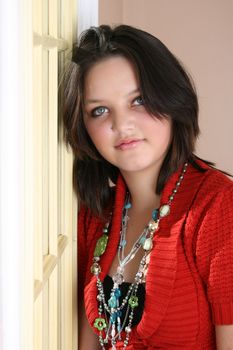 Beautiful brunette female leaning against a door on a sunny day