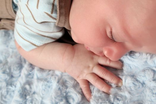 Beautiful newborn baby boy sleeping on a soft blanket