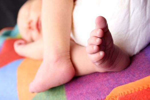 Newborn baby sleeping on a soft blanket. Focus on foot