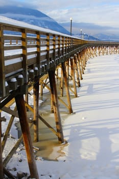 Wooden pier with snow at frozen lake in Salmon Arm 