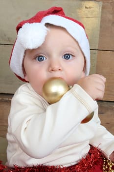 Baby boy wearing a christmat hat playing with decorations