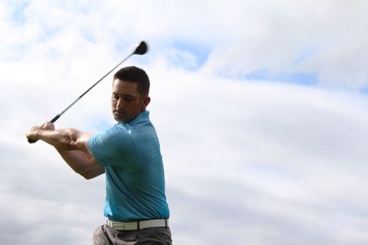 Young golfer hitting a shot with a fairway wood