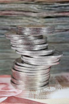 Stack of Canadian dollar bills with coins in front