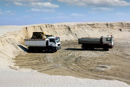 bulldozer loading truck with sand