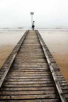 teenage girl standing on old sea pier, Italy