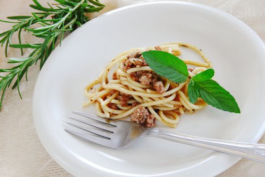 small portion of spaghetti mixed with minced meat served on white plate