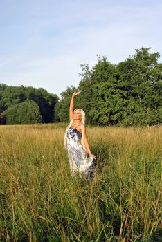 Blonde girl alone in field. Freedom.