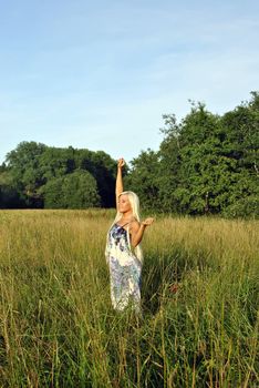 Blonde girl alone in field. Freedom.