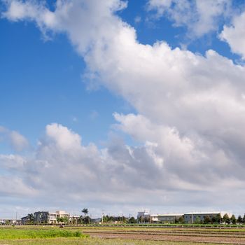 Landscape of countryside with green farm under blue sky in sunny day.