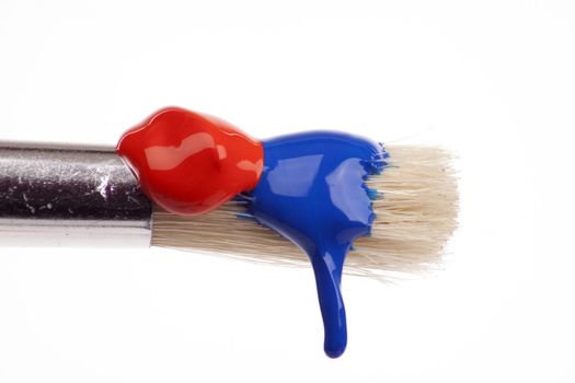 paint brush dripping with different coloured paints