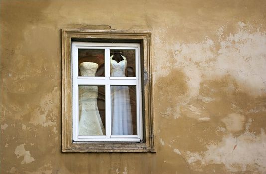 wedding dresses in the window of the old house 