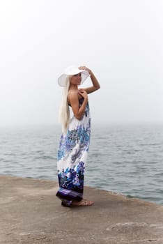 Girl in hat standing in the misty sea