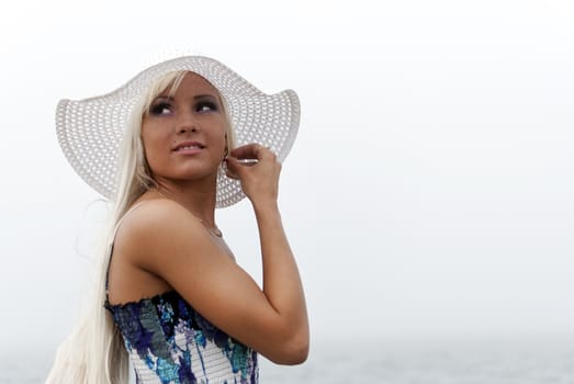 Girl in hat standing in the misty sea