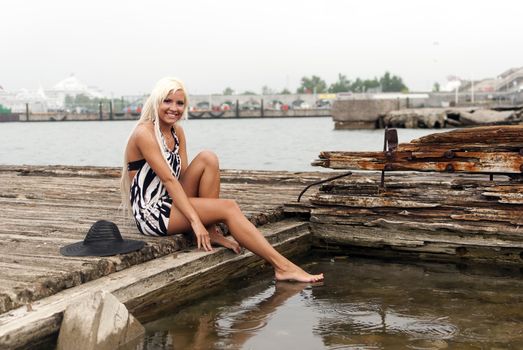 girl in a hat sitting on a broken ship at sea