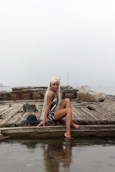 girl in a hat sitting on a broken ship at sea