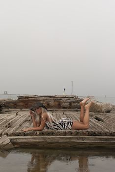 girl in a hat lying on a broken ship at sea