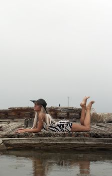 girl in a hat sitting on a broken ship at sea