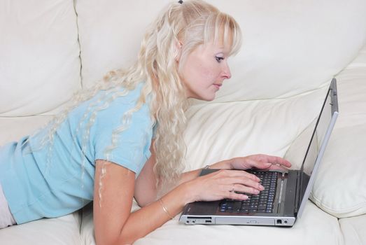 portrait of blond woman on sofa with notebook computer