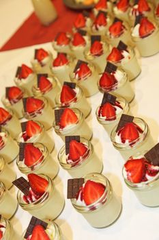 Many, sweet desserts with strawberries and chocolate - served in little bowls 
