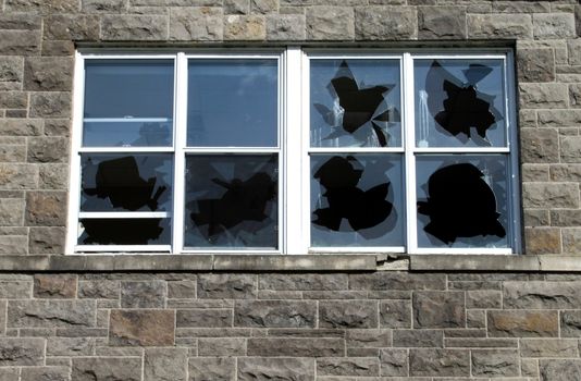 Broken windows by vandalism on historic building
