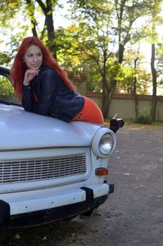 redheaded girl near the old car