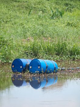 Two blue drums filled with chemicals in a river