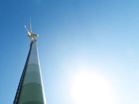 Wind turbine under the sun during  a clear blue sky