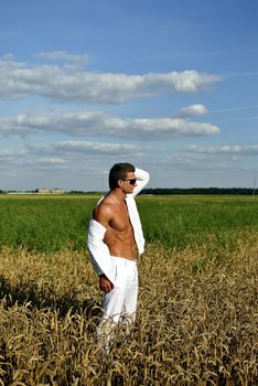 Bodybuilder with sunglasses dressed in white on the field