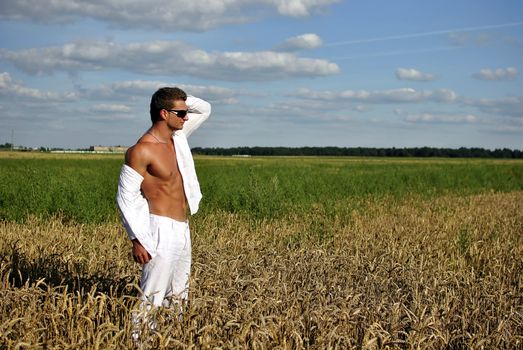 Bodybuilder with sunglasses dressed in white on the field