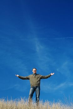 successful and happy man stay on a background of the blue sky