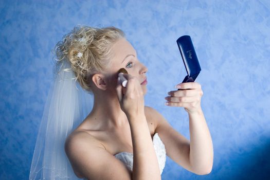 a blond bride make a make up in the morning