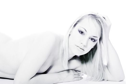 Studio portrait of a young blond woman lying down naked